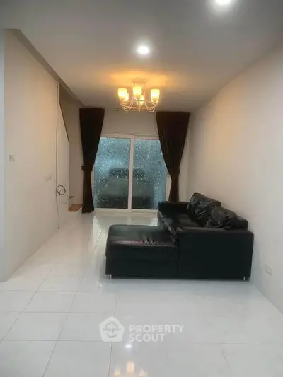 Spacious living room with modern lighting and large window view