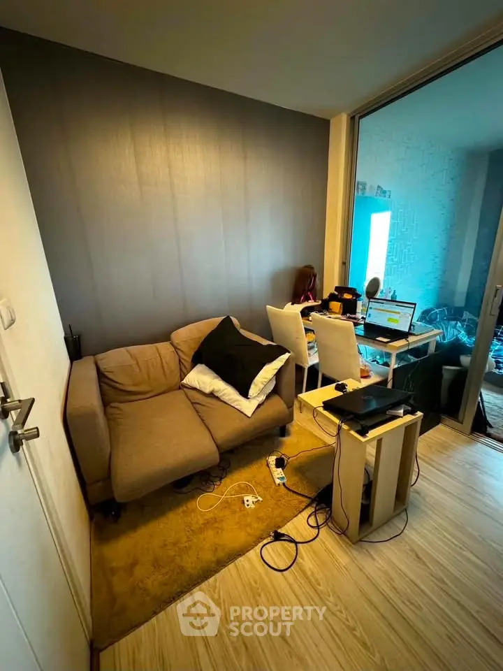 Cozy living room with modern decor and workspace setup, perfect for urban living.
