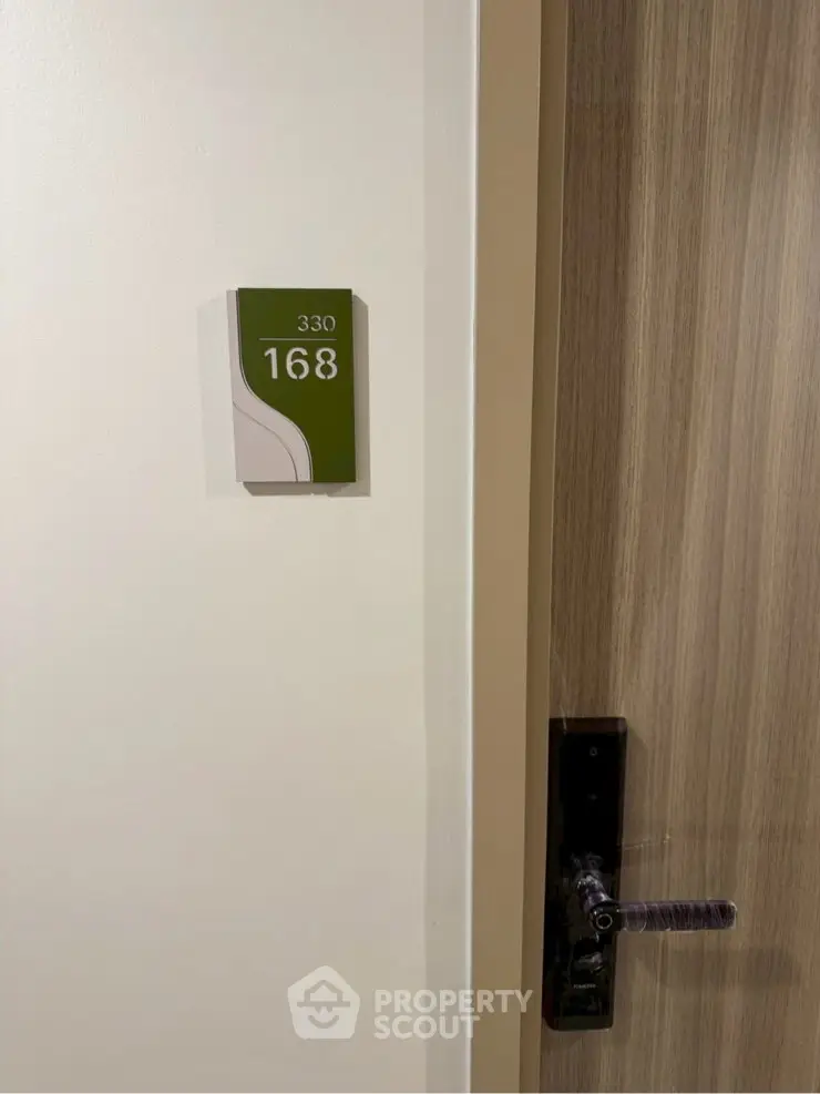 Modern apartment door with room number 168 and sleek handle design.