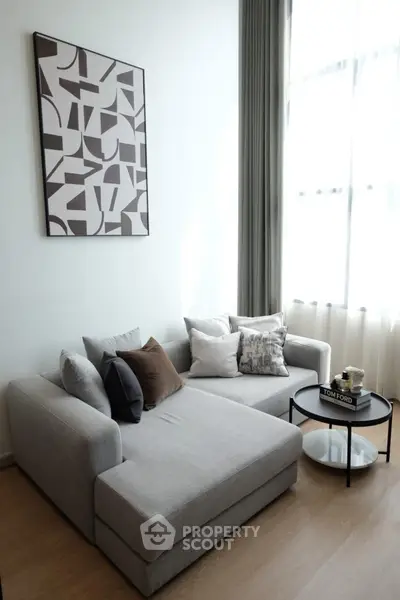 Modern living room with stylish gray sofa and abstract wall art