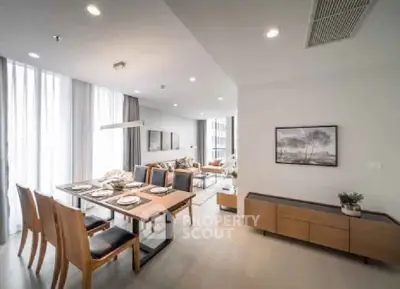 Spacious modern dining and living area with elegant decor and natural light.