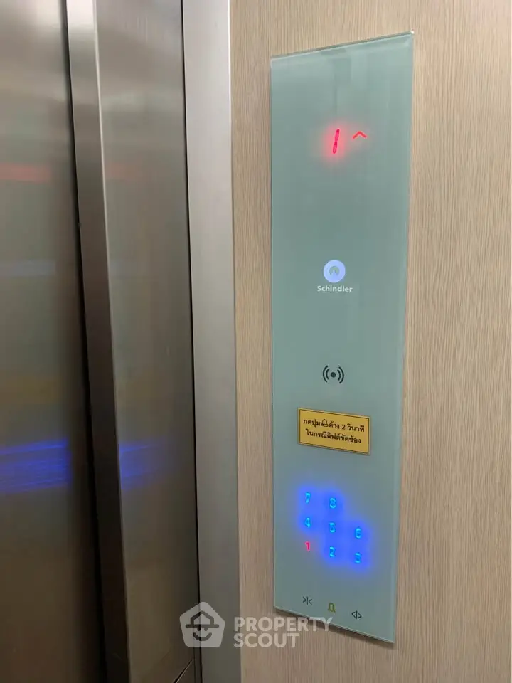 Modern elevator panel with touch controls in a sleek residential building.