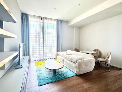 Modern living room with cozy sofa, stylish decor, and large window for natural light.