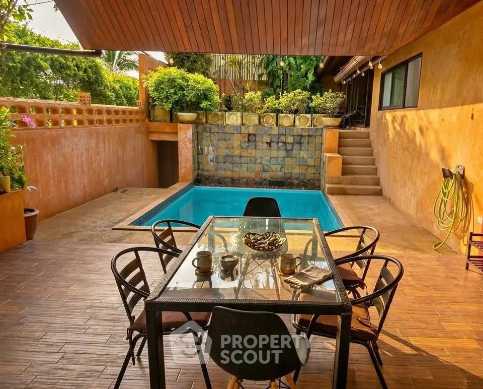 Charming outdoor patio with pool and dining area, perfect for relaxation and entertaining.