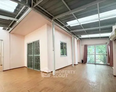 Spacious open-plan living area with large windows and modern flooring, perfect for natural light and comfort.