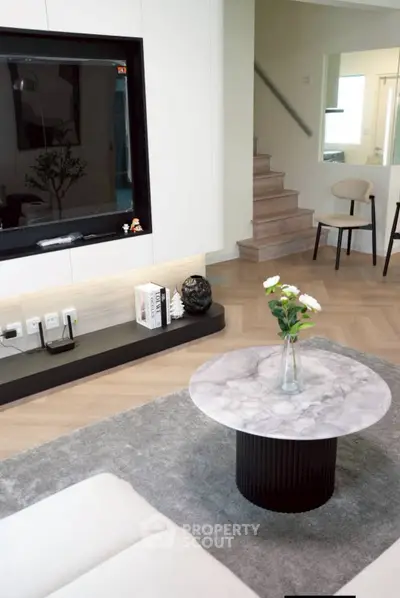 Modern living room with marble coffee table and sleek TV setup