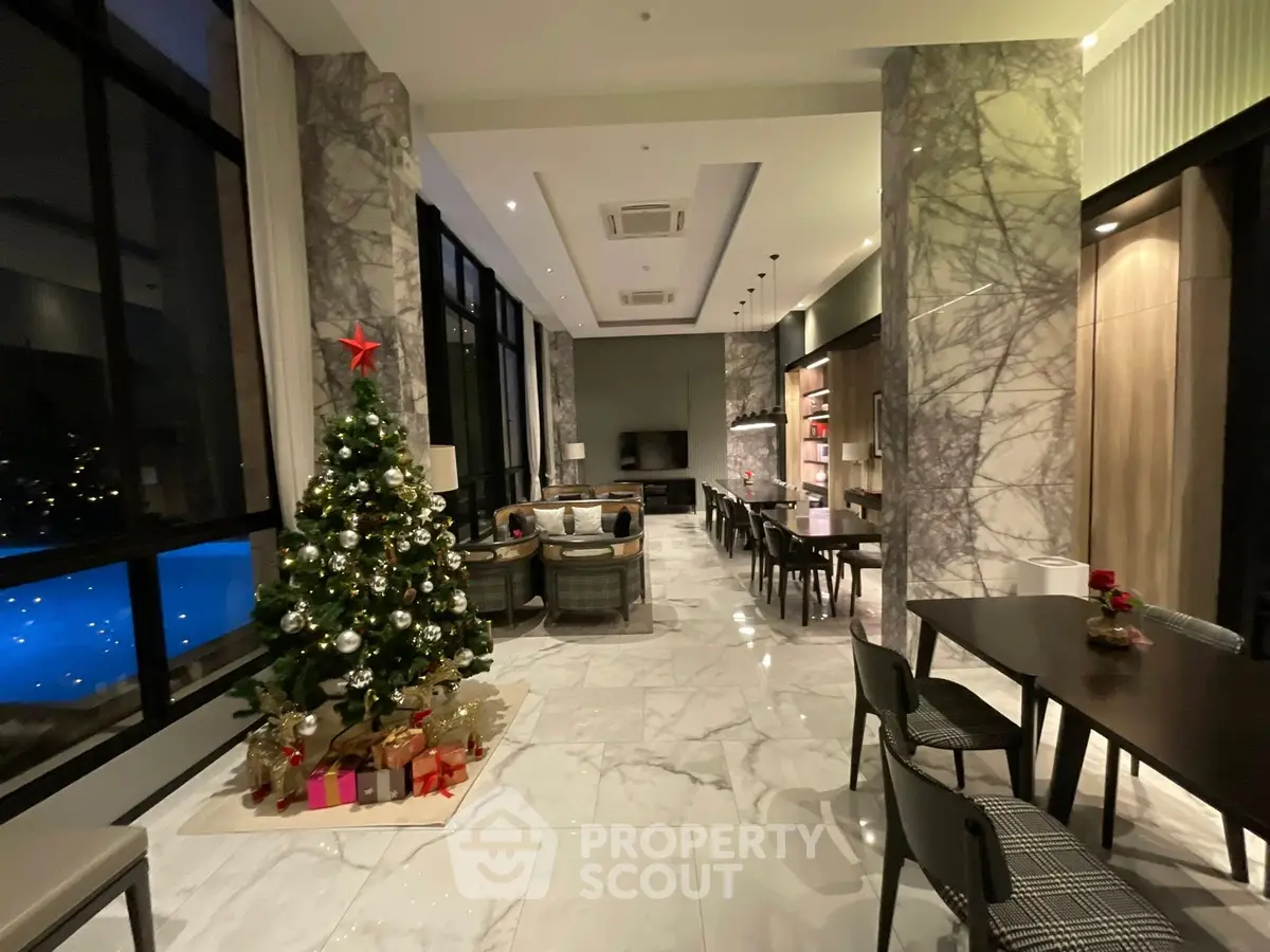 Luxurious living room with marble floors and Christmas decor, overlooking a pool.