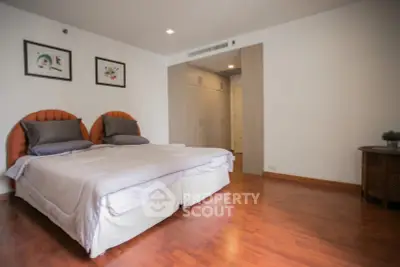 Spacious bedroom with wooden flooring and stylish decor