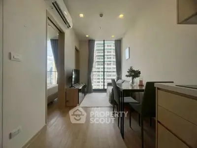 Modern apartment interior with open layout, featuring a cozy living area and dining space with city view.