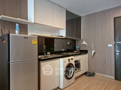 Modern kitchen with sleek appliances and stylish cabinetry in a compact layout.