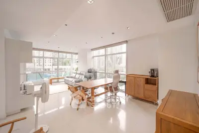 Spacious modern living room with large windows and city view, featuring elegant furniture and natural light.