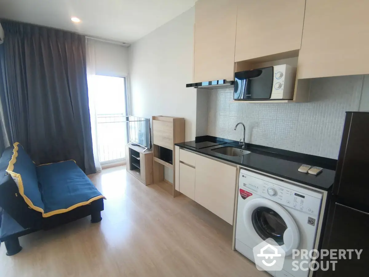 Modern studio apartment with integrated living space featuring a sleek kitchenette, cozy sitting area, and ample natural light, perfect for urban living.