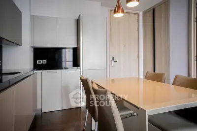 Modern dining area with sleek cabinetry and elegant lighting in a contemporary apartment.