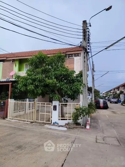 Charming townhouse with gated entrance and lush greenery in a peaceful neighborhood.