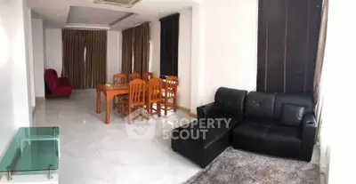 Spacious living room with modern furniture and dining area, perfect for family gatherings.