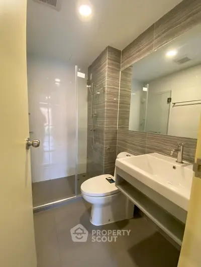 Modern bathroom with sleek design and glass shower enclosure.