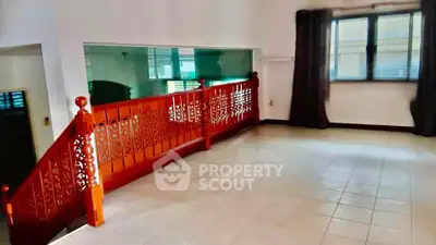Spacious room with elegant wooden railing and large windows, perfect for modern living.