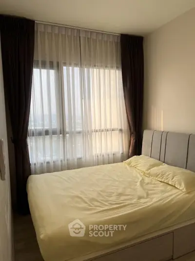 Cozy bedroom with large window and soft lighting, perfect for relaxation.