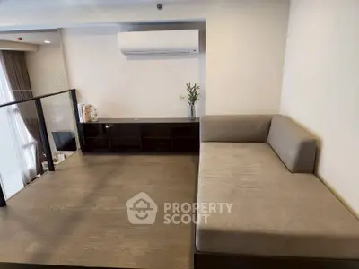 Modern living room with sleek sofa and air conditioning, featuring elegant wooden flooring.