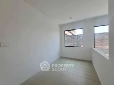 Bright empty room with large windows and wooden flooring
