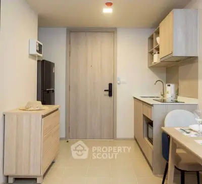 Modern kitchen with sleek cabinetry and compact design in cozy apartment.