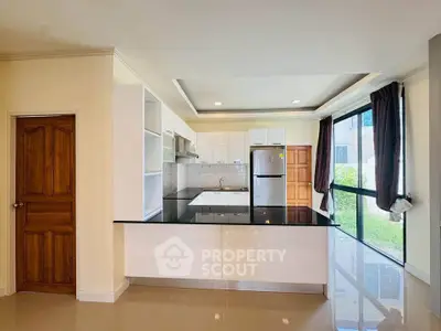 Spacious modern kitchen with sleek black countertops and ample natural light