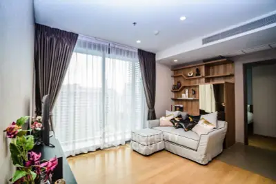 Modern living room with large window and stylish decor in a high-rise apartment.
