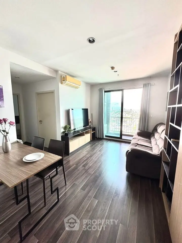 Modern living room with sleek furniture and large window offering city view