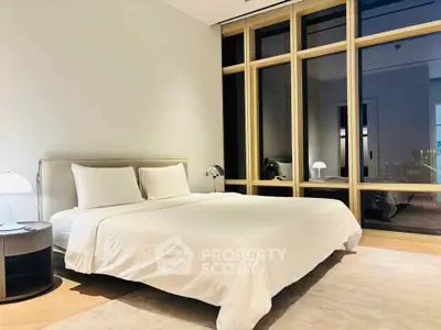 Luxurious bedroom with large windows and modern decor in a high-end apartment.