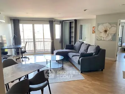 Spacious modern living room with large windows and stylish furniture in a bright apartment.