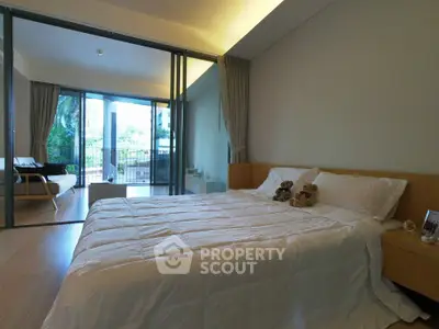 Spacious bedroom with large windows and balcony access, offering serene views and abundant natural light.