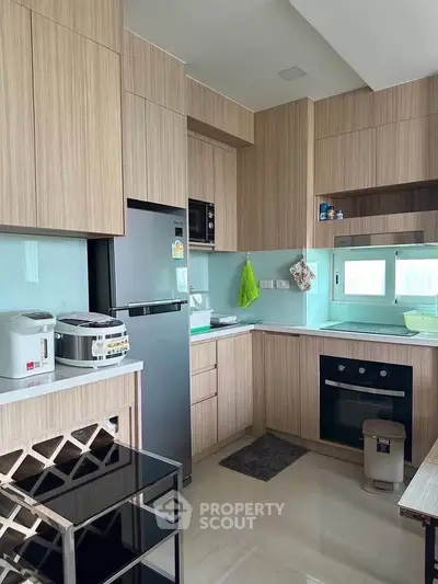 Modern kitchen with sleek cabinetry and built-in appliances, featuring a closed layout and gas stove.