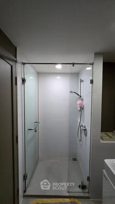 Modern bathroom with glass shower enclosure and sleek fixtures.
