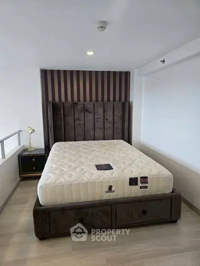 Modern bedroom with stylish bed and elegant side table in a cozy apartment.
