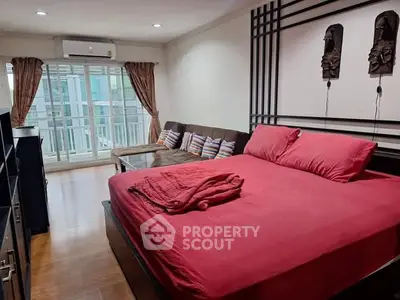 Spacious bedroom with modern decor and balcony access in a stylish apartment.