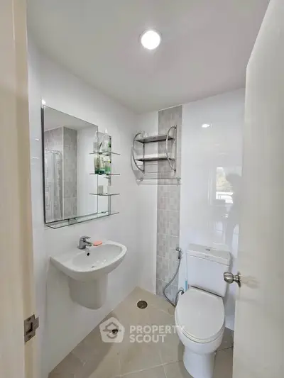 Modern bathroom with sleek fixtures and neutral tiles in a contemporary apartment.
