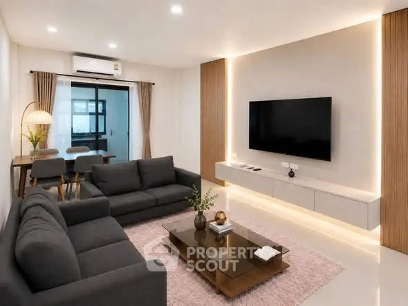 Modern living room with sleek furniture and ambient lighting, featuring a wall-mounted TV and stylish decor.