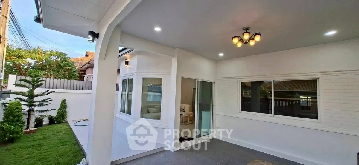 Modern home exterior with spacious covered patio and lush green garden.