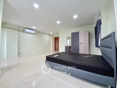 Spacious bedroom with modern furnishings and ample natural light