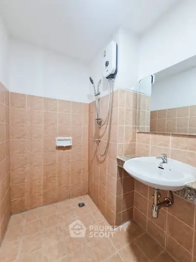 Modern bathroom with tiled walls and electric shower heater