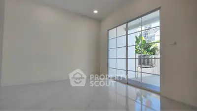 Spacious empty room with sliding glass doors leading to a balcony, perfect for customization.