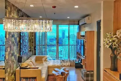 Luxurious living room with stunning city view, elegant chandelier, and modern decor in high-rise apartment.