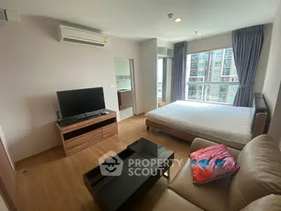 Modern bedroom with large window, TV, and air conditioning in a stylish apartment.
