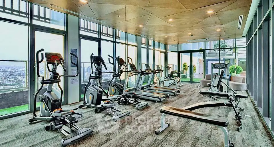 Luxurious high-rise gym with panoramic city views and modern fitness equipment.