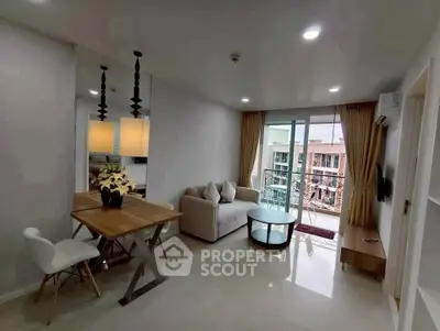 Modern living room with balcony view, stylish furniture, and ample natural light in a contemporary apartment.