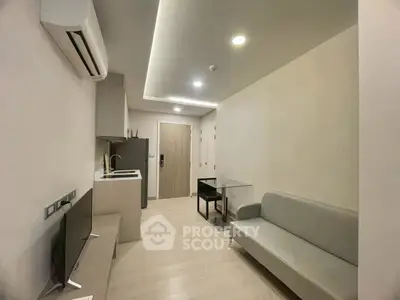 Modern minimalist living room with sleek furniture and integrated kitchen area.