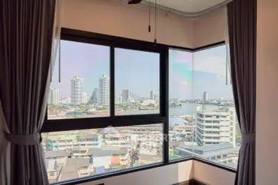 Stunning corner unit with panoramic city and river views, featuring large windows and elegant curtains.