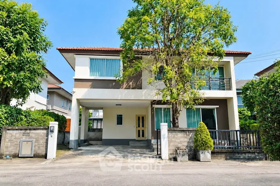 Charming two-story house with lush greenery and modern design in a serene neighborhood.