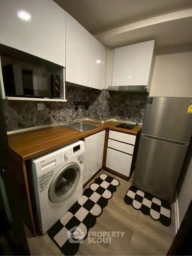 Compact modern kitchen with washing machine and sleek appliances