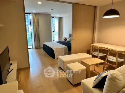Modern open-plan living room and bedroom with stylish furniture and natural light.